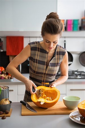 simsearch:400-07956836,k - Young housewife removing filling from pumpkin Foto de stock - Royalty-Free Super Valor e Assinatura, Número: 400-07956537