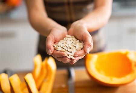 simsearch:400-07956836,k - Closeup on young housewife showing pumpkin seeds Foto de stock - Royalty-Free Super Valor e Assinatura, Número: 400-07956540