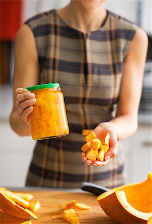 simsearch:400-07956018,k - Closeup on young housewife showing jar of pickled pumpkin and pumpkin slices Stockbilder - Microstock & Abonnement, Bildnummer: 400-07956555