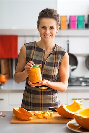 simsearch:400-07956018,k - Portrait of happy young housewife showing jar of pickled pumpkin Stockbilder - Microstock & Abonnement, Bildnummer: 400-07956553