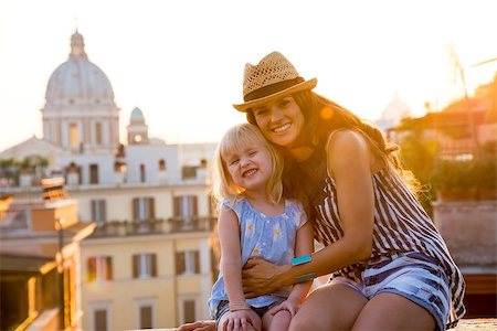 simsearch:400-08864986,k - Portrait of happy mother and baby girl sitting on street overlooking rooftops of rome on sunset Stock Photo - Budget Royalty-Free & Subscription, Code: 400-07956608