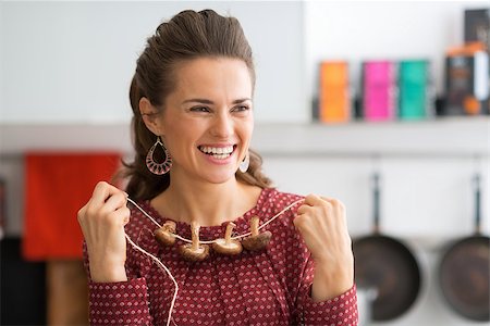 simsearch:400-07956886,k - Portrait of happy young housewife using mushrooms on string as necklace Photographie de stock - Aubaine LD & Abonnement, Code: 400-07956785