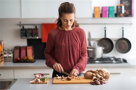 simsearch:400-07217319,k - Young housewife cutting mushrooms in kitchen Stock Photo - Budget Royalty-Free & Subscription, Code: 400-07956802