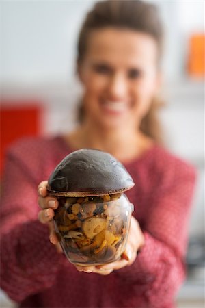 simsearch:400-07956886,k - Closeup on happy young housewife showing jar of pickled mushrooms Photographie de stock - Aubaine LD & Abonnement, Code: 400-07956824