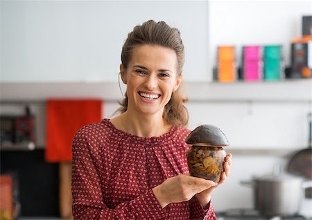 simsearch:400-07956886,k - Portrait of happy young housewife showing jar of pickled mushrooms Photographie de stock - Aubaine LD & Abonnement, Code: 400-07956821