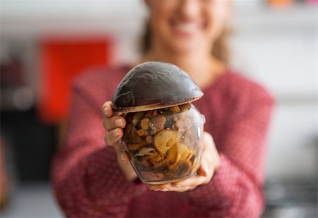 simsearch:400-07956886,k - Closeup on happy young housewife showing jar of pickled mushrooms Photographie de stock - Aubaine LD & Abonnement, Code: 400-07956823