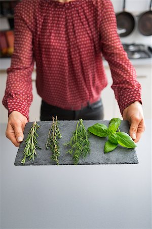 simsearch:400-07956886,k - Closeup on young housewife showing fresh spices herbs on stone substrate Photographie de stock - Aubaine LD & Abonnement, Code: 400-07956869