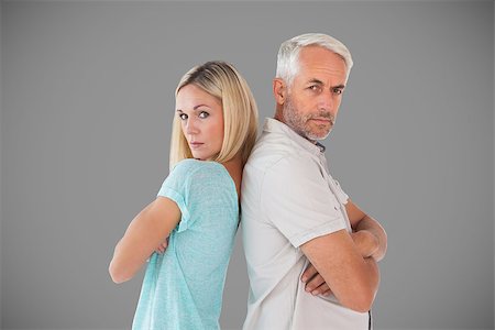 simsearch:400-07726578,k - Unhappy couple not speaking to each other  against grey Fotografie stock - Microstock e Abbonamento, Codice: 400-07957094