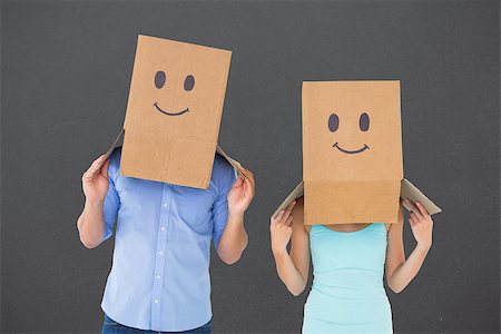 Couple wearing emoticon face boxes on their heads against grey Stock Photo - Budget Royalty-Free & Subscription, Code: 400-07957090