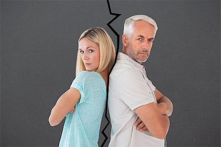 simsearch:400-07726578,k - Unhappy couple not speaking to each other  against grey Fotografie stock - Microstock e Abbonamento, Codice: 400-07957105