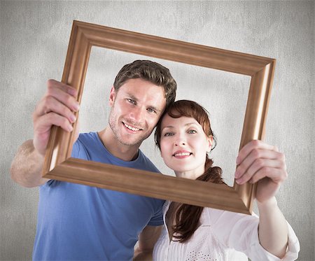 simsearch:400-07957339,k - Couple holding frame ahead of them against weathered surface Photographie de stock - Aubaine LD & Abonnement, Code: 400-07957325