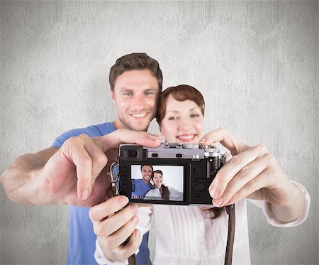 simsearch:400-07957460,k - Couple using camera for picture against weathered surface Foto de stock - Super Valor sin royalties y Suscripción, Código: 400-07957323