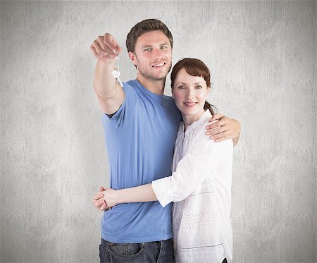 simsearch:400-07957339,k - Couple holding keys to home against weathered surface Photographie de stock - Aubaine LD & Abonnement, Code: 400-07957332