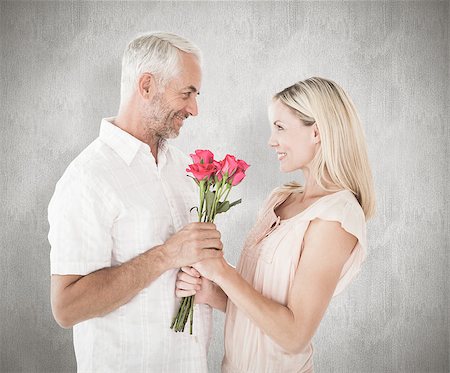 Affectionate man offering his partner roses against weathered surface Photographie de stock - Aubaine LD & Abonnement, Code: 400-07957387