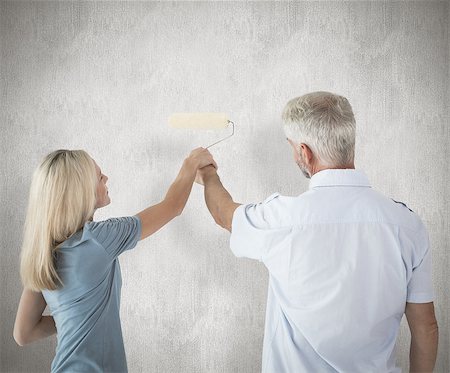 simsearch:400-07957430,k - Happy couple painting wall with roller against weathered surface Photographie de stock - Aubaine LD & Abonnement, Code: 400-07957399