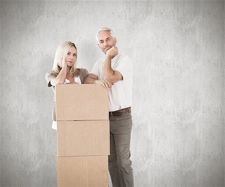 Happy couple leaning on pile of moving boxes against weathered surface Photographie de stock - Aubaine LD & Abonnement, Code: 400-07957404