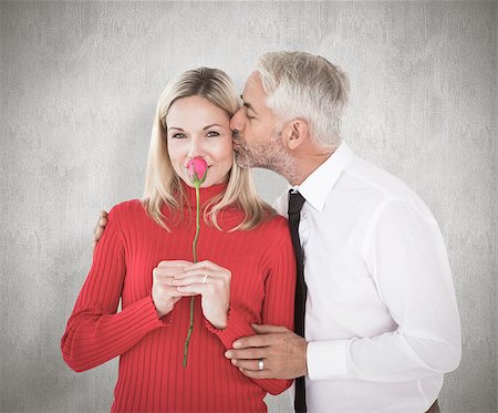 simsearch:400-07957339,k - Handsome man giving his wife a kiss on cheek against weathered surface Photographie de stock - Aubaine LD & Abonnement, Code: 400-07957415