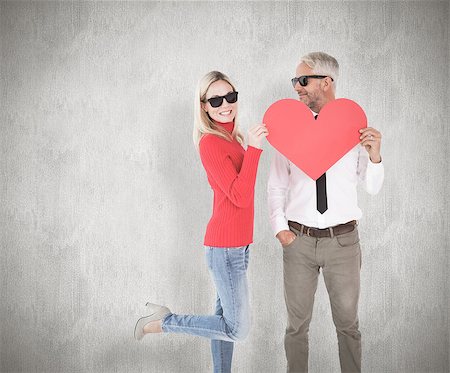 simsearch:400-07957391,k - Cool couple holding a red heart together against weathered surface Foto de stock - Super Valor sin royalties y Suscripción, Código: 400-07957416