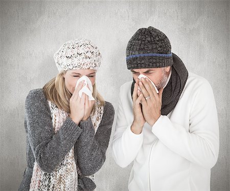 simsearch:400-07957430,k - Sick couple in winter fashion sneezing against weathered surface Photographie de stock - Aubaine LD & Abonnement, Code: 400-07957425