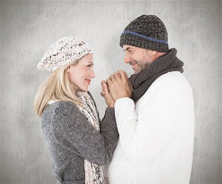 simsearch:400-07957430,k - Couple in winter fashion embracing against weathered surface Photographie de stock - Aubaine LD & Abonnement, Code: 400-07957428