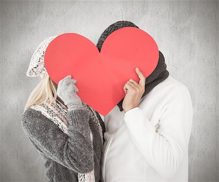 simsearch:400-07957430,k - Couple in winter fashion posing with heart shape against weathered surface Photographie de stock - Aubaine LD & Abonnement, Code: 400-07957429