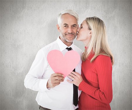 simsearch:400-07957627,k - Handsome man holding paper heart getting a kiss from wife against weathered surface Foto de stock - Super Valor sin royalties y Suscripción, Código: 400-07957421