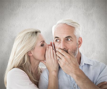 Woman whispering a secret to husband against weathered surface Photographie de stock - Aubaine LD & Abonnement, Code: 400-07957423