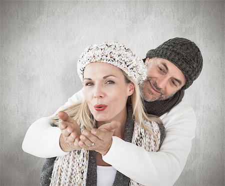 simsearch:400-07957339,k - Smiling couple in winter fashion posing against weathered surface Photographie de stock - Aubaine LD & Abonnement, Code: 400-07957433