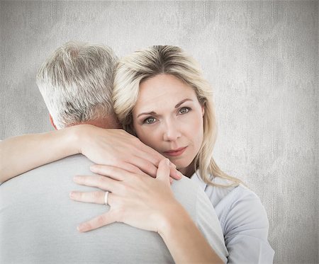 simsearch:400-07957339,k - Unhappy blonde hugging her husband against weathered surface Photographie de stock - Aubaine LD & Abonnement, Code: 400-07957441