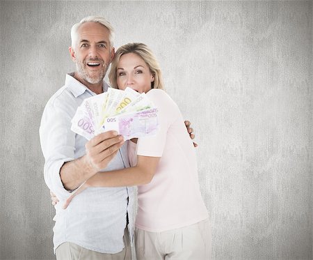 Happy couple flashing their cash against weathered surface Photographie de stock - Aubaine LD & Abonnement, Code: 400-07957455