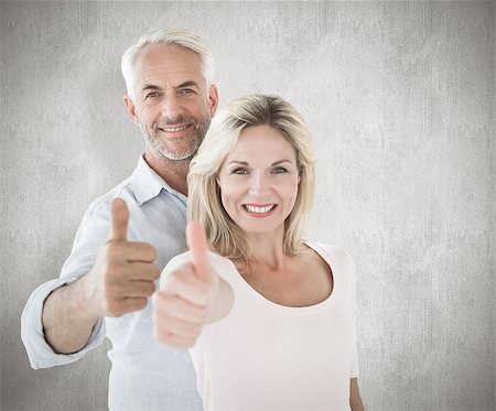 Smiling couple showing thumbs up together against weathered surface Photographie de stock - Aubaine LD & Abonnement, Code: 400-07957458