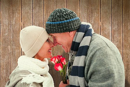 simsearch:400-07957430,k - Happy mature couple in winter clothes with roses against wooden planks Photographie de stock - Aubaine LD & Abonnement, Code: 400-07957618