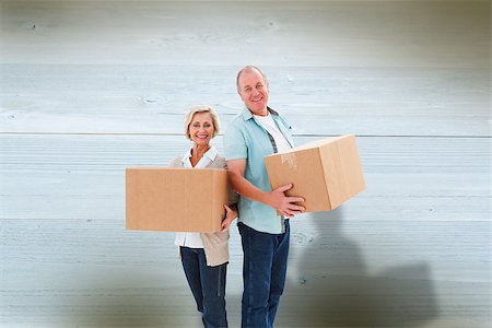 Older couple smiling at camera holding moving boxes against bleached wooden planks background Photographie de stock - Aubaine LD & Abonnement, Code: 400-07957639