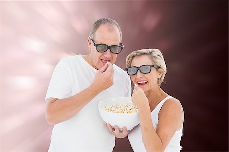 simsearch:400-07957805,k - Mature couple wearing 3d glasses eating popcorn against valentines heart design Photographie de stock - Aubaine LD & Abonnement, Code: 400-07957815