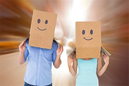 Couple wearing emoticon face boxes on their heads against blurry new york street Stock Photo - Budget Royalty-Free & Subscription, Code: 400-07957836
