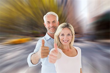 Smiling couple showing thumbs up together against blurry new york street Stock Photo - Budget Royalty-Free & Subscription, Code: 400-07957831