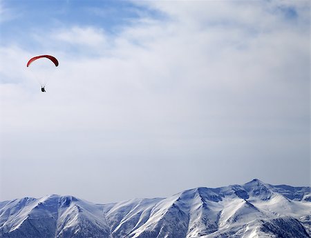 Paraglider silhouette of mountains in sunlight sky. Caucasus Mountains. Georgia, ski resort Gudauri. Foto de stock - Super Valor sin royalties y Suscripción, Código: 400-07951309