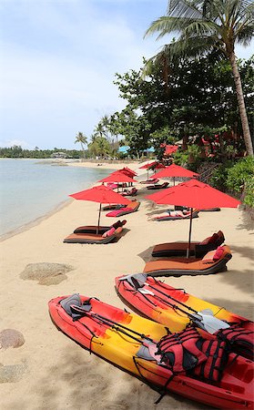 resort outdoor bed - exotic beach with red umbrellas and kayaks sunny day Foto de stock - Super Valor sin royalties y Suscripción, Código: 400-07952057
