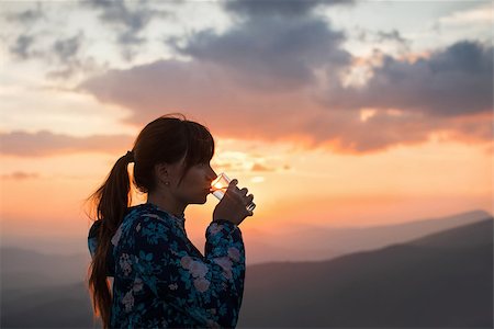 Woman drinking water from glass with sunset backlight at the mountains Stock Photo - Budget Royalty-Free & Subscription, Code: 400-07952834