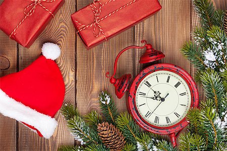 Christmas wooden background with clock, snow fir tree, gift boxes and santa hat Stock Photo - Budget Royalty-Free & Subscription, Code: 400-07952874