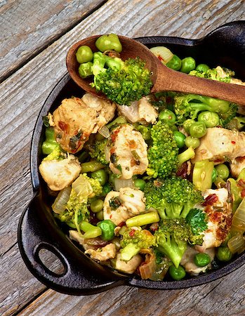 simsearch:400-07481067,k - Homemade Chicken Stew with Broccoli, Bell Pepper and Green Pea in Black Saucepan with Wooden Spoon closeup on Rustic Wooden background. Top View Stock Photo - Budget Royalty-Free & Subscription, Code: 400-07953090