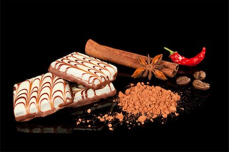 simsearch:400-08789726,k - Exquisite chocolate candy with cinnamon and chili arranged on black background. Photographie de stock - Aubaine LD & Abonnement, Code: 400-07953540
