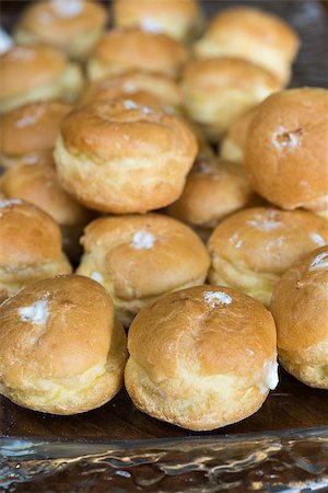 simsearch:400-04835290,k - Looking at a glass plate filled with delicious decadent cream puffs.  Shot on a wood table. Stock Photo - Budget Royalty-Free & Subscription, Code: 400-07976723