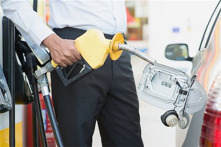 Close up Asian man pumping gasoline fuel in car at gas station. Foto de stock - Super Valor sin royalties y Suscripción, Código: 400-07978328