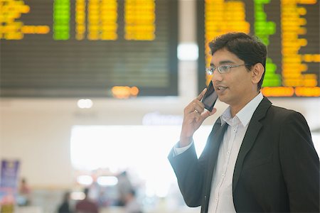 Asian Indian Business man on the phone during his business travel, at the airport . Photographie de stock - Aubaine LD & Abonnement, Code: 400-07978335