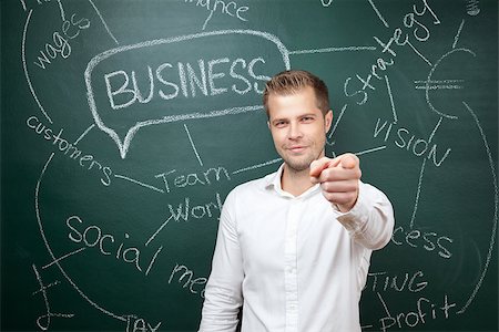 simsearch:400-08863576,k - Young business man standing in front of a blackboard with a business plan Stock Photo - Budget Royalty-Free & Subscription, Code: 400-07971405