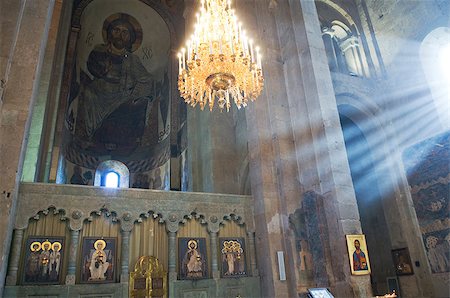 Inside of ancient church includes fresco, stone iconostasis, holy gates and the grand chandelier on center. Shoots of sunlight penetrate intrerior space of church. Photographie de stock - Aubaine LD & Abonnement, Code: 400-07972224