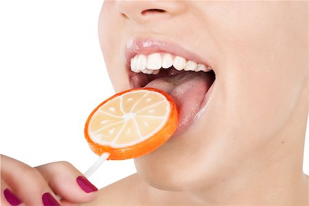 Detail of a young girl licking a round colorful lollipop isolated on white background with clipping path. Glamour shot. Stock Photo - Budget Royalty-Free & Subscription, Code: 400-07973048