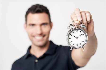 Cheerful young man with alarm clock Stock Photo - Budget Royalty-Free & Subscription, Code: 400-07984952