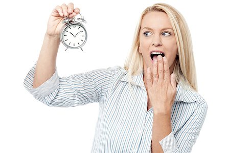 Middle aged woman shocked and holding alarm clock Stock Photo - Budget Royalty-Free & Subscription, Code: 400-07985256